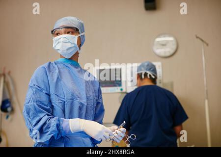 Shes got life saving experience. Shot of a surgeon ready to perform a surgery in an operating room. Stock Photo