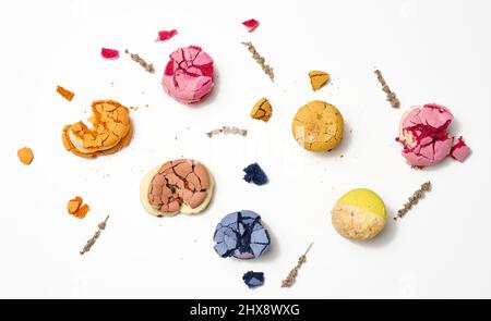 broken round macarons with crumbs on a white background, delicious dessert, top view Stock Photo