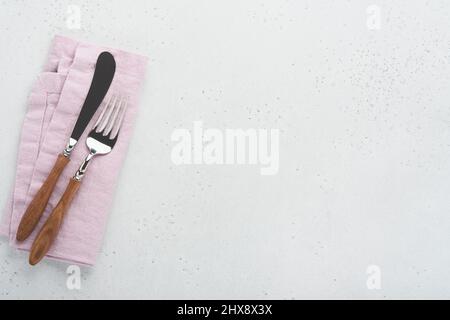 Vintage silverware. Rustic vintage set of wooden spoon and fork on light gray concrete background. Empty dishes. Top view. Mock up. Stock Photo