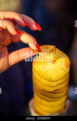 Tasting on a spiral of roasted potatoes. Stock Photo