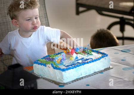 Child having his 2nd birthday party, his face , a boy with his cake Stock Photo