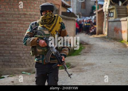 Indian Paramilitary Trooper stands on guard along the street near a gunfight site at Naina Batpora village in south Kashmir's Pulwama district. Two militants affiliated with Lashkar-e- Toiba were killed in an encounter with security forces at Naina Batpora area of South Kashmir's Pulwama district. A senior police officer told the local news agency that two militants were killed in an operation, as the joint team of forces intensified searches towards the suspected spot, the hiding militants fired upon the forces triggering off a gunfight. Stock Photo