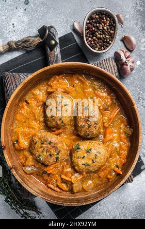 Cutlets or Fish balls with tuna in tomato sauce. Gray background. Top view Stock Photo