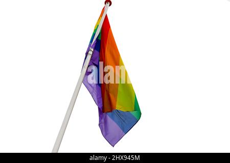 A rainbow flag is hung on the mast, which is visible on a white background. Stock Photo
