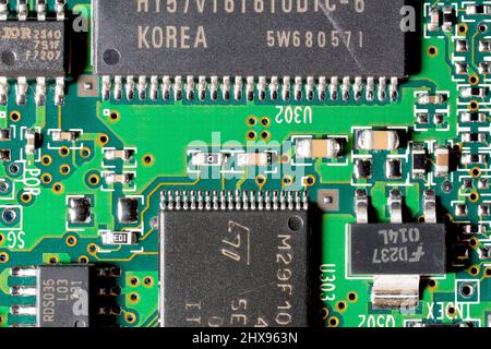 Close up detail of a computer circuit board, showing various sizes of integrated chips and other electronic components. Stock Photo