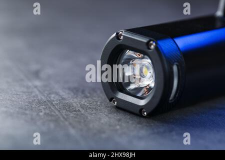 Black Rechargeable Flashlight handheld, LED close-up on a black background Stock Photo