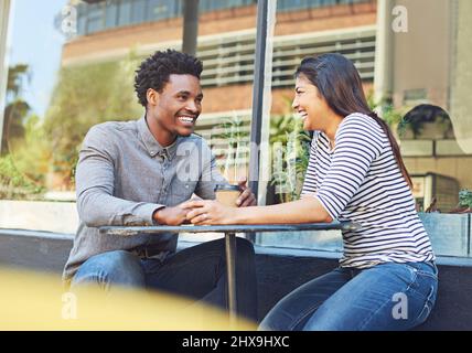 Their feelings grow deeper everyday. Shot of a young couple on a coffee date at a sidewalk cafe. Stock Photo