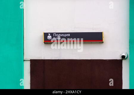 a signboard of the police office installed above the entrance to the building, a video surveillance camera is fixed next to the door, selective focus Stock Photo