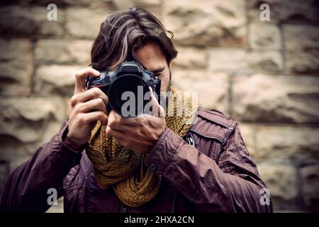Photography is my passion. Shot of a handsome young photographer at work in the city. Stock Photo