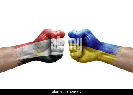 Two hands punch to each others on white background. Country flags painted fists, conflict crisis concept between tajikistan and ukraine Stock Photo