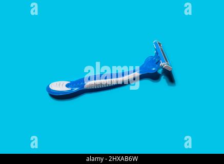 Disposable shaving razors on blue background Stock Photo