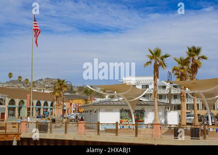 Pismo Beach, California, USA - March 3, 2022.  Pismo Beach Pier plaza. Shops, restaurants, walking people, downtown of city, city life Stock Photo