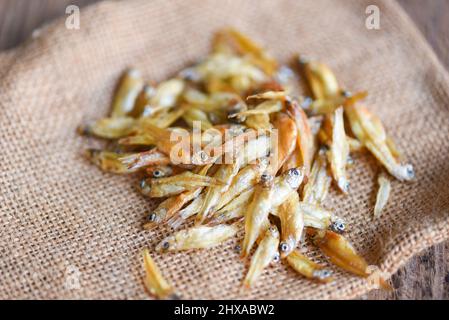 Small dried fish on the sack background, Crispy fish for snack Stock Photo