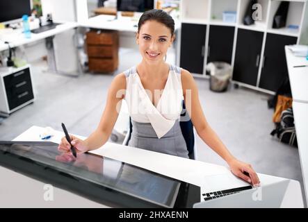 Touch the face of the future. A young businesswoman using touch technology. Stock Photo