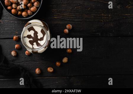 Hazelnut spread with nuts set, on black wooden table background, top view flat lay, with copy space for text Stock Photo