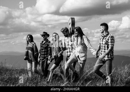 Group people summer outdoor. Groups of Friends Relaxing are Enjoying Outside Tents Camping. Group of beautiful teens arriving at summer festival. Stock Photo