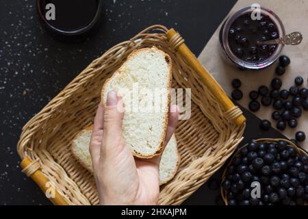 Top view of the woman hand holding a piece of loaf Stock Photo