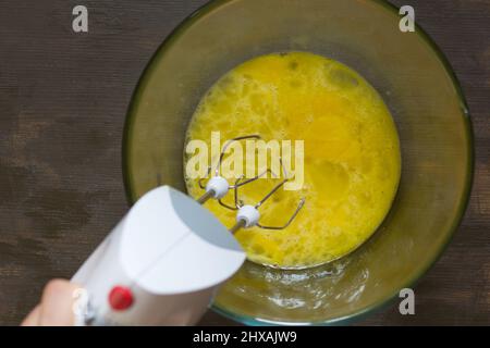 Electric mixer whisking egg whites in a glass bowl Stock Photo - Alamy