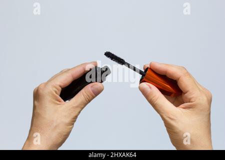 Hands of woman holding mascara on the white background Stock Photo