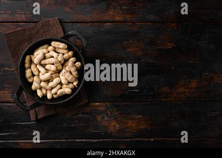 Dried peanuts. Tasty groundnuts set, on old dark wooden table background, top view flat lay, with copy space for text Stock Photo