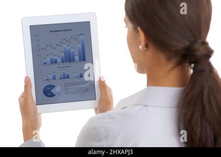 Staying on top of the business statistics. Over the shoulder shot of a businesswoman looking at financial data on a digital tablet. Stock Photo