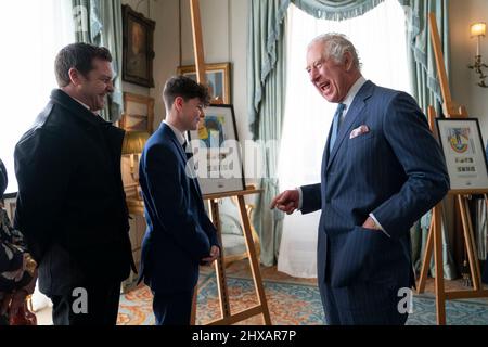 The Prince of Wales meets Alfie Craddock, aged 12, a national winner of Royal Mail's 'Heroes of the Pandemic' stamp design competition, while viewing the winning designs at Clarence House in London. Picture date: Thursday March 10, 2022. Stock Photo