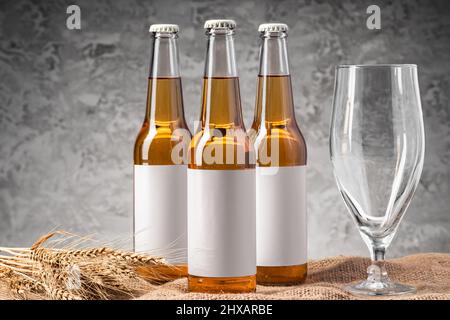 Beer bottle and beer glass against gray background Stock Photo