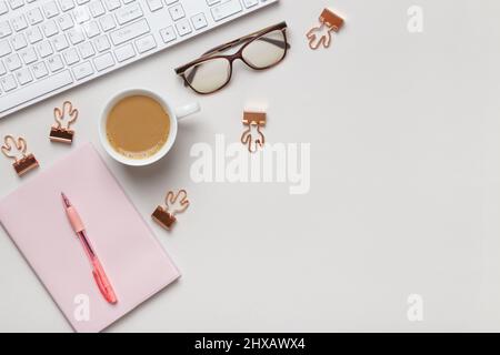 Top view desktop. Notepad glasses keyboard cup of coffee on the table. Stock Photo
