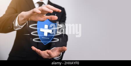 Businessman hold Shield with plus Low polygonal icon, medicine icon.Health shield.Medical logo template,protection symbol with cross sign,healthcare s Stock Photo