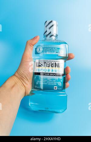 Tyumen, Russia-February 06, 2022: Listerine on blue background. Listerine is a brand of antiseptic mouthwash product. Vertical photo Stock Photo