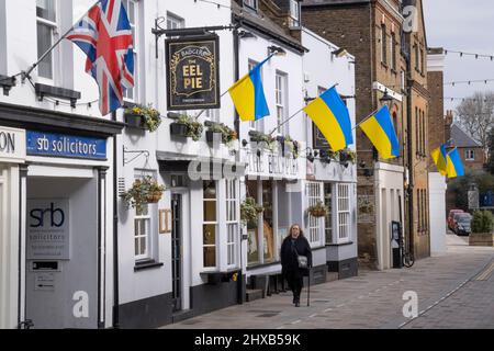 As the war in Ukraine enters its third week, Ukrainian flags hang alongside British Union Jacks above 'The Eel Pie' pub on Church Street, Twickenham, on 10th March 2022, in London, England. The initiative was organised by The Church Street of Twickenham Association showing solidarity and sympathy with local Ukrainians, saying: 'Showing solidarity with our Ukrainian brothers and sisters. We feel for you and your horrific ordeal. Stay strong!' Stock Photo