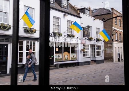 As the war in Ukraine enters its third week, Ukrainian flags hang above 'The Eel Pie' pub on Church Street, Twickenham, on 10th March 2022, in London, England. The initiative was organised by The Church Street of Twickenham Association showing solidarity and sympathy with local Ukrainians, saying: 'Showing solidarity with our Ukrainian brothers and sisters. We feel for you and your horrific ordeal. Stay strong!' Stock Photo