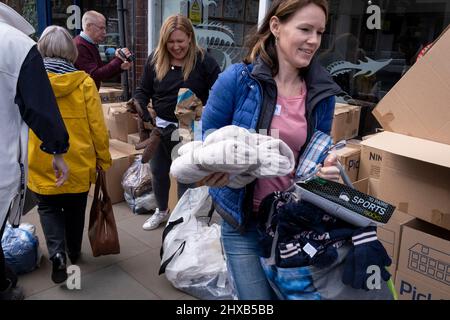 As the war in Ukraine enters its third week, volunteers based at the Ukrainian restaurant 'Prosperity' in Twickenham, handle a mass of donations brought by locals, destined for Ukrainian refugees who have reached Poland, on 10th March 2022, in London, England. Volunteers are working 12-hour days here trying to keep up with thousand of items eg. clothing, sleeping bags, toys, womens' sanitary products, rucksacks, elctrical chargers, nappies and basic medicines for those who have escaped the Russian invasion. Stock Photo
