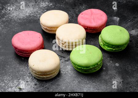 Colorful french macarons set, on black dark stone table background Stock Photo