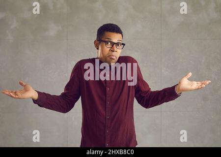Portrait of confused handsome young african american man with raised arms Stock Photo