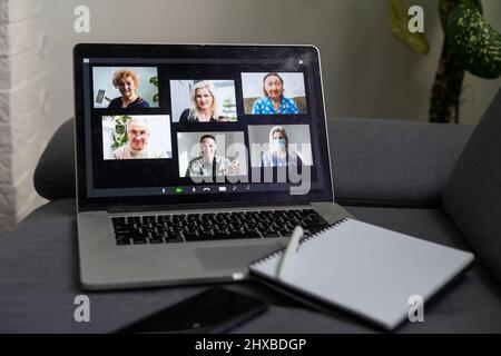 Laptop screen with multi-person conference, collage of group of multiracial people, webcam view, video chat. A lot of different headshots on computer Stock Photo