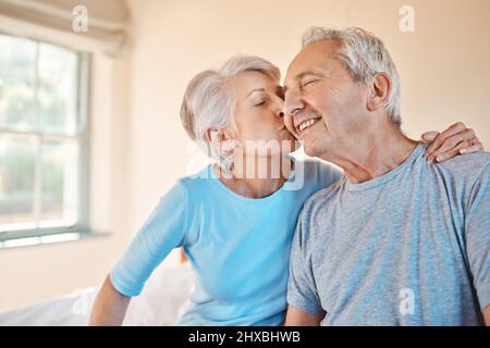 Youre the best. Cropped shot of an affectionate senior woman kissing her happy husband on the cheek in a nursing home. Stock Photo