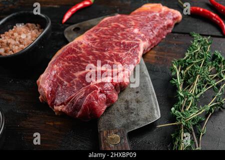 Raw Grass Fed NY Strip Steaks with Salt and Pepper set, on old dark wooden table background Stock Photo