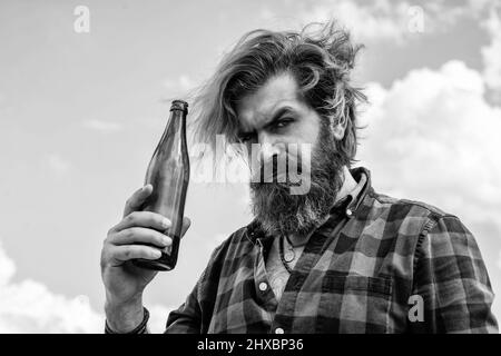 brutal man with water. refresh with water. bearded man wear checkered shirt. casual male relax while drinking beer. concept of alcohol drinking. man Stock Photo