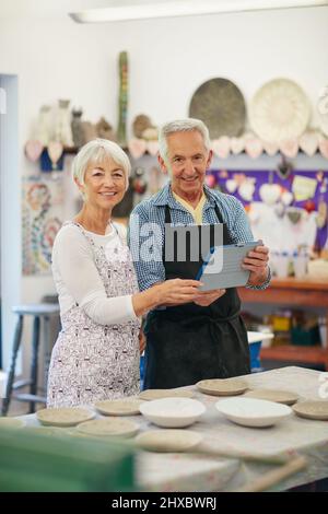 Our online pottery business is now live. Shot of a senior couple working with ceramics in a workshop. Stock Photo