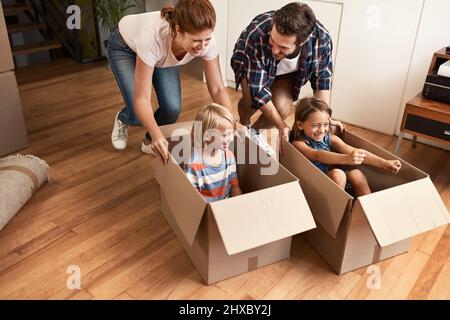 There is an adventure in moving house. Shot of a young family on their moving day. Stock Photo