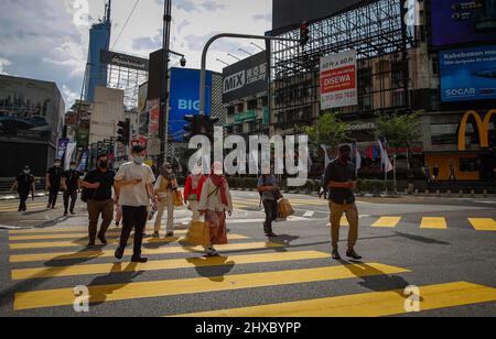 Kuala Lumpur, Malaysia. 10th Mar, 2022. Pedestrians wearing face masks as a precaution against the spread of covid-19 seen crossing the street near the shopping district. (Photo by Wong Fok Loy/SOPA Images/Sipa USA) Credit: Sipa USA/Alamy Live News Stock Photo