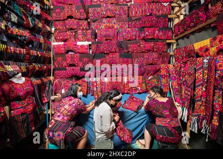 Dresses and fabric are for sale at the colorful weekly Chichicastenango Mayan Market in Guatemala, Central America. Stock Photo