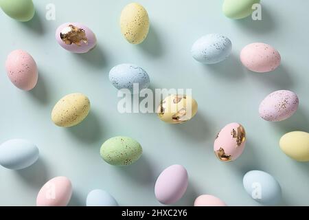 Easter pattern with pastel eggs on blue background. View from above. Flat lay. Happy Easter greeting card. Stock Photo