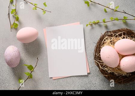 Easter greeting card with pink eggs in decorative nest on gray background. View from above. Greeting card with copy space. Stock Photo