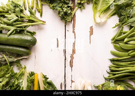 Directly above shot fresh green vegetables and herbs on wooden table with empty space Stock Photo