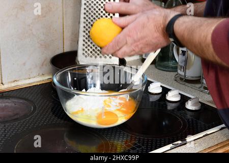Step 6 Using Grater to add Lemon (Citrus limon) Zest to the mixture Hook Norton Oxfordshire England uk Stock Photo