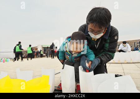 Ishinomaki, Japan. 11th Mar, 2022. People light paper lanterns at Ishinomaki Minamihama Tsunami Recovery Memorial Park, Ishinomaki, Miyagi-prefecture, Japan on Friday, March 11, 2022. Photo by Keizo Mori/UPI Credit: UPI/Alamy Live News Stock Photo