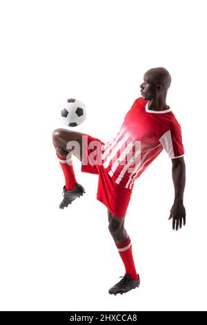 Skilled male african american soccer player kicking ball over white background Stock Photo