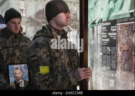 Lviv, Ukraine. 11th Mar, 2022. Ukrainian soldiers seen holding a photo of a dead soldier and a cross during the funeral service. The funeral of the three Ukrainian soldiers killed during the Russian Invasion of Ukraine, has been held in Lviv, at Saints Peter and Paul Garrison Church (also known as Jesuit Church). Credit: SOPA Images Limited/Alamy Live News Stock Photo